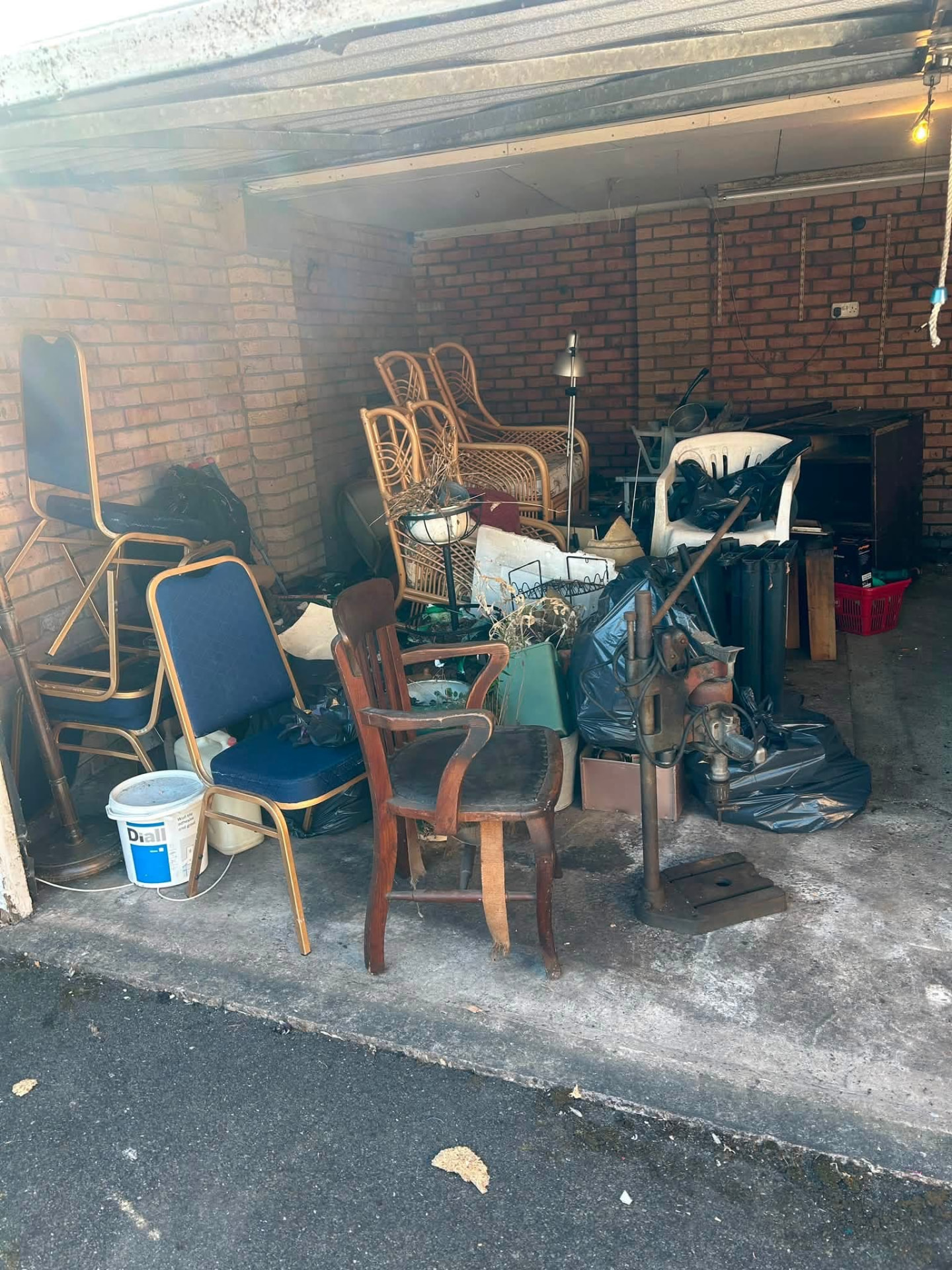 A garage full of chairs, bags and old equipment before a full house clearance in the West Midlands
